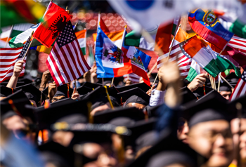 Graduates in a crowd waving flags Graduates in a crowd waving flags